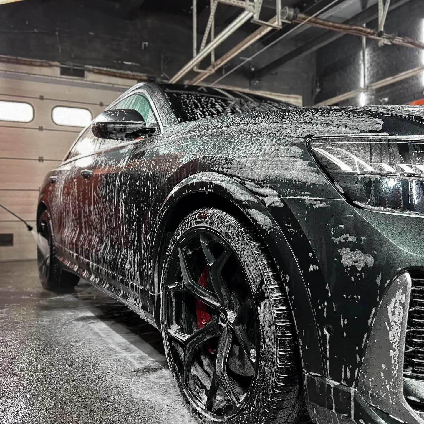 Audi RS Q8 в пене у оранжевой шторки в боксе